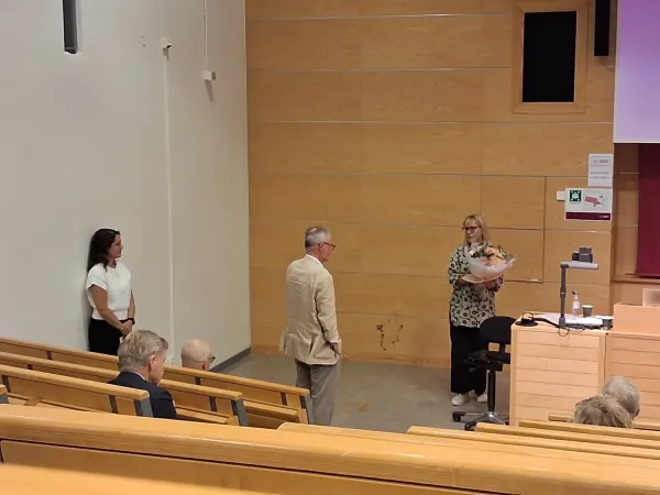 Carin Lennartsson with flowers to Johan Fritzell. Neda Agahi is also in the picture