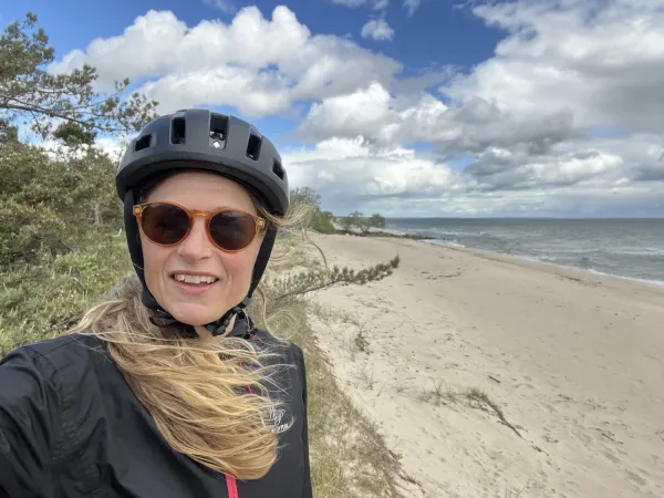 Pernilla Alencar Siljehag with her hair blowing in the wind, at a beach during the tandem tour.