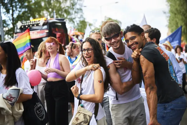 Three KI students show their tattoos in the Pride Parade.