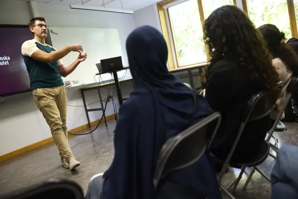 A man standing in a classroom in front of a school class.
