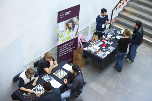 People standing and sitting around two tables.