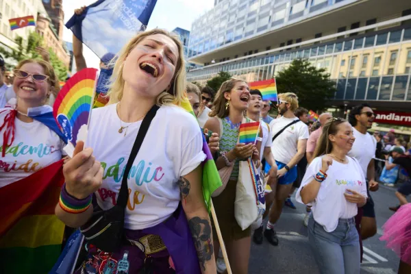 Ester Bonér with a fan in rainbowcolours smiling.
