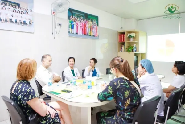 Five people around table discussing.