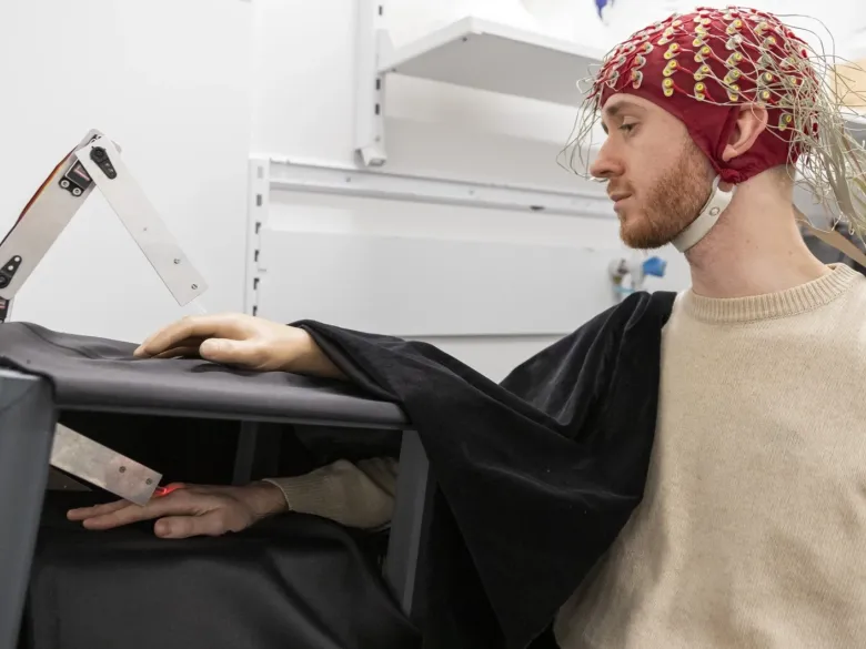 Setup of experiment where a test subject i wearing a helmet recording signals in the brain.