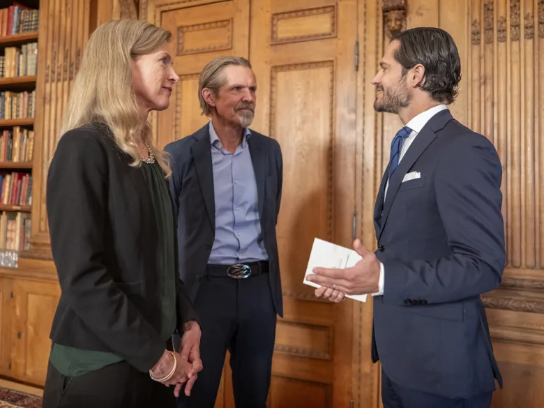 Photo of a woman and two men talking