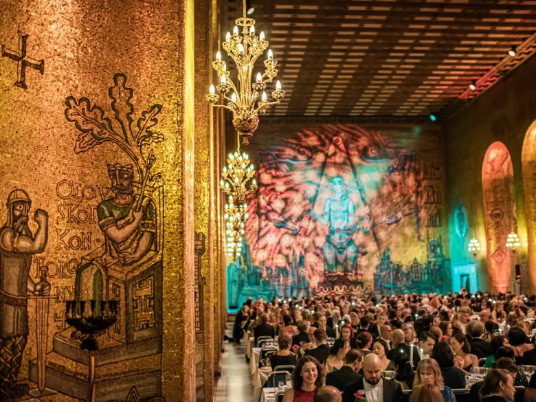 Artwork on the wall of the Golden Hall with banquet guests seated in the background.