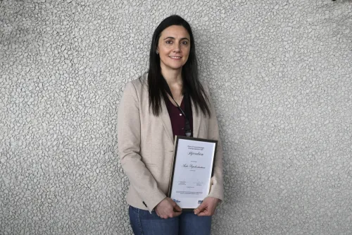 Andri Papakonstantinou is holding a diploma.