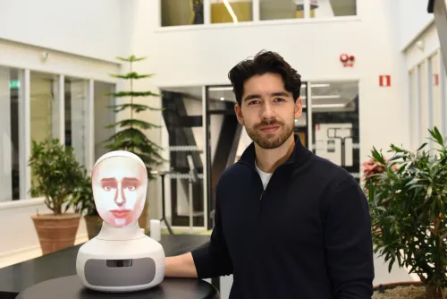 Alexander Borg, doctoral student at the Department of Medicine, Solna, next to the AI-driven robot patient used in teaching at KI.