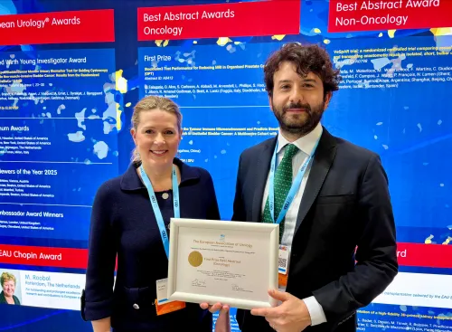 Two researchers at the EAU conference holding a diploma