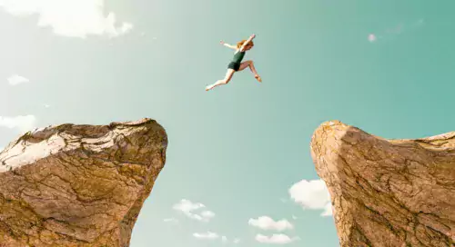 Girl jumping from cliff to cliff.