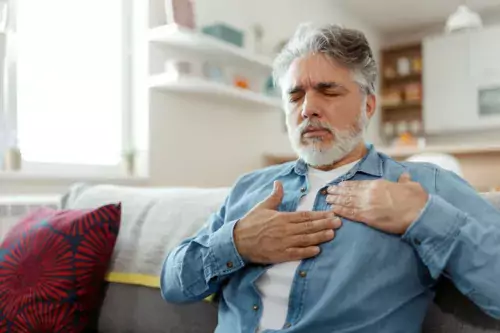 Male suffering from bad pain in his chest heart attack at home - heart disease