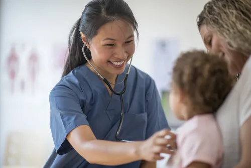 A nurse is listening to a little girl's heart with a stetoscope.