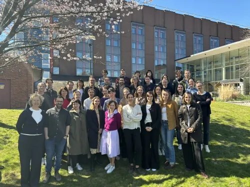 Group picture of the course participants on the grass in the sun.