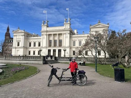 Oskar Jonsson standing with his tandem bike in front of a building.