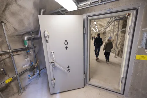 A door in a underground shelter and people walking through it