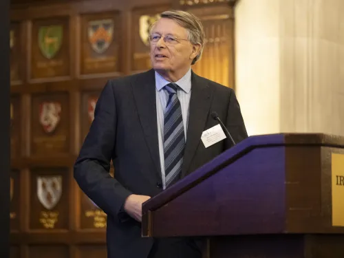 Olle ten Cate by a podium giving a lecture.