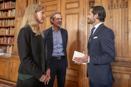 Photo of a woman and two men talking