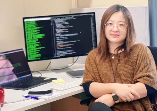 Portrait photo of Ping Chen at the Department of Laboratory Medicine who is sitting by her desk looking into the camera.