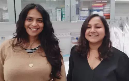 Picture of Postdoctoral researcher Samudyata Samudyata and PhD student Susmita Malwade standing in their lab