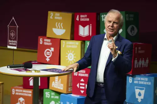 Ole Petter Ottersen speaking and lifting a finger. UN&#039;s sustainable development goals in background.