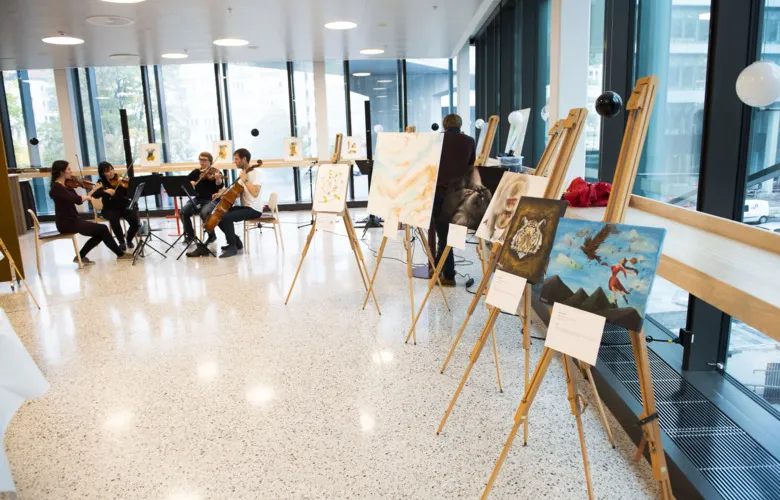 Chamber music ensemble in the background with art pieces in the foreground.