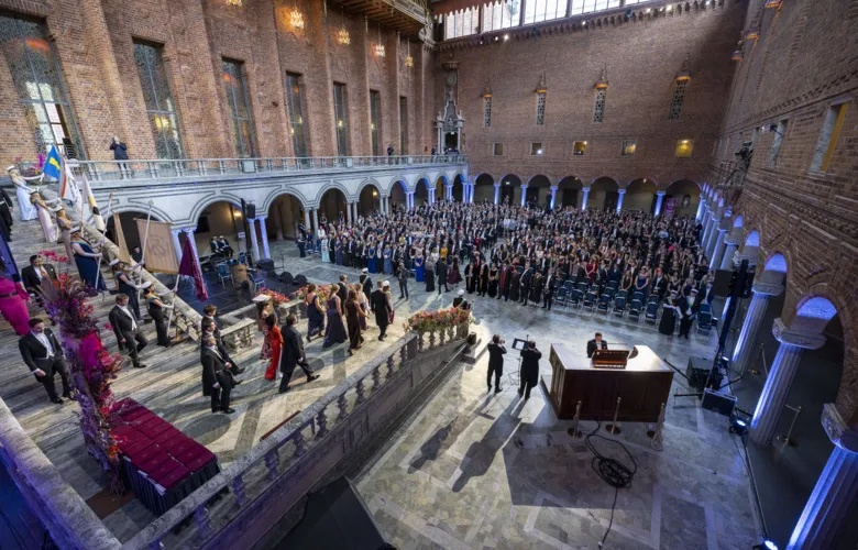 Overview picture of the Blue Hall, Stockholm City Hall, during the conferment ceremony. The doctors are walking down the stairs in front of the audience.