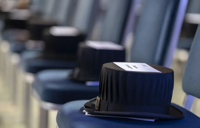 Doctor&#039;s hats and name tags on chairs standing in a row.