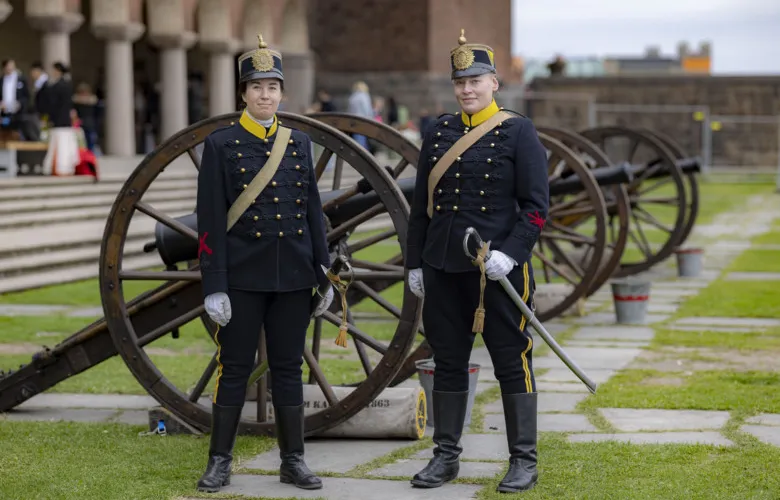 Two people in festive costumes are waiting to fire a salute.