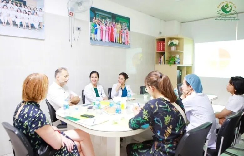 Five people around table discussing.